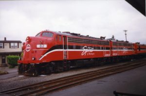 Image of the Spirit of Washington Dinner Train: a red train with a black and white stripe going down the side, stopped on the tracks.
