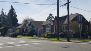 Image of three early 1900s homes in a row on a sunny block